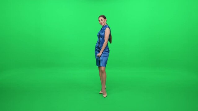 Elegant woman in a blue dress walking on a green background, a chroma key template, woman actor posing.