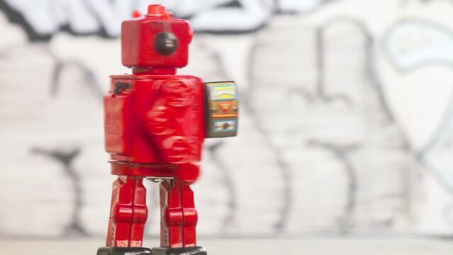 Bright red Robot marching in a loop with a futuristic laser gun, spinning and rotating  1950s-1960s sci-fi toys.