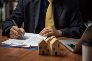 businessman holding a pen looking at documents Selling real estate, insurance, buying a house and paying land taxes. Making contracts and legal agreements.