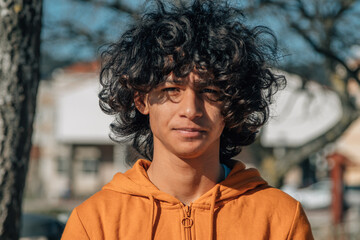 portrait of young man with afro hair and sweatshirt in the street