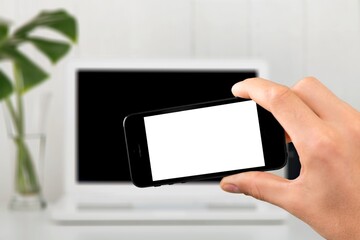 Blank screen phone on laptop background