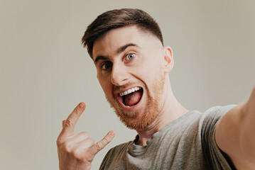 Handsome caucasian man taking a selfie portrait indoor at home - Happy guy smiling at the camera.