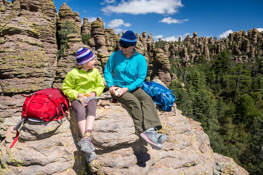 Mother and daughter resting while hiking in Heart of Rocks, Chiricahua National Monument, Willcox, Arizona, USA