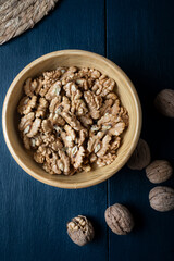 Walnut kernel halves, in a wooden bowl. Close-up, from above.