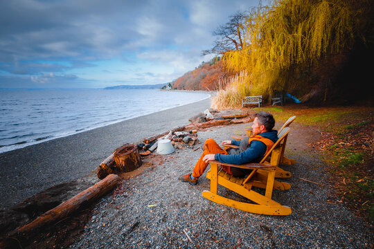 A man is sitting in s chair near Puget Sound