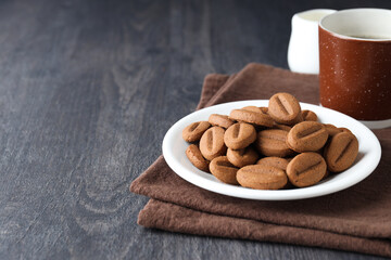 Concept of tasty snack for hot drink - cookies in the shape of coffee seeds