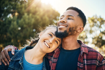 Fototapeta premium Young couple hug in park, summer and outdoor date together in sunshine, happiness and nature. Happy man hugging woman in garden for love, care and support with diversity partner, relax and smile face
