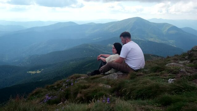 couple hikers resting on the top of Hoverla mount in Ukraine