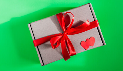 box with red ribbon on a green background. High quality photo. chroma