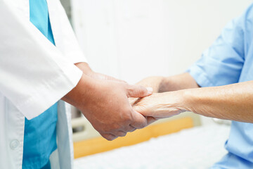 Doctor holding hands Asian elderly woman patient, help and care in hospital.