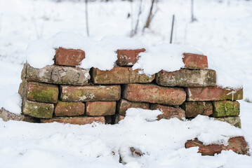 Heap of weathered red brick in the snow