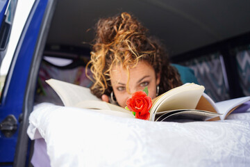 portrait of woman reading a book with a rose looking at camera. Sant Jordi. Day of the book