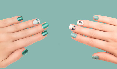 Two Female hands with blue nail design on blue background. Glitter blue nail polish manicure. Nails...