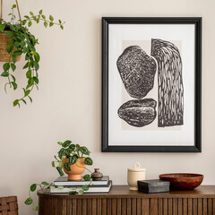 Domestic and cozy interior of living room with mock up poster frame, wooden commode, plants, black...