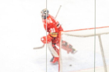 blurred view through protective safety glass. hockey goalie on the ice of the winter stadium, background