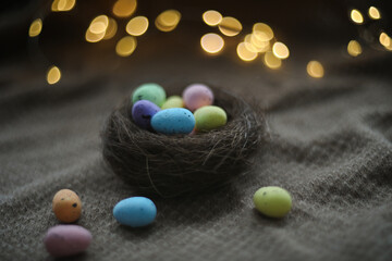 Happy Easter card. Colorful easter eggs in nest on rustic festive background with copy space, selective focus image. 