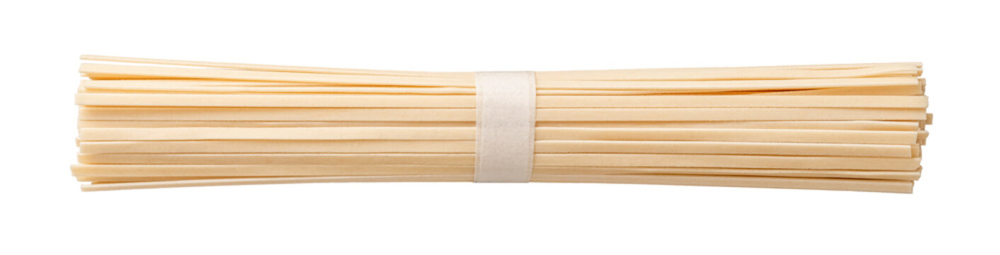 Raw udon nudles bunch cutout. Bundle of dried asian vegan pasta from wheat flour isolated on a white background. Macro. Japanese cuisine concept.