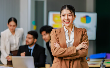 Portrait of a happy Asian young professional successful female businesswoman in formal business suit standing pose working in company office