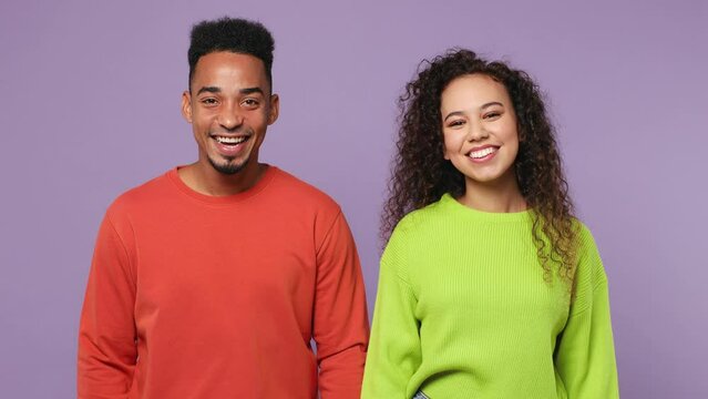 Young couple two friends family man woman of African American ethnicity wear casual clothes together meeting together greeting giving high five clap hands folded isolated on plain purple background