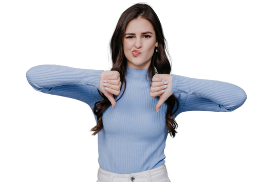 Beautiful European brunette in a lilac sweater and white pants, shows her thumbs down, wrinkled her face, looks at camera on transparent background. Bad decision. Mockup, decline, refuse. Against