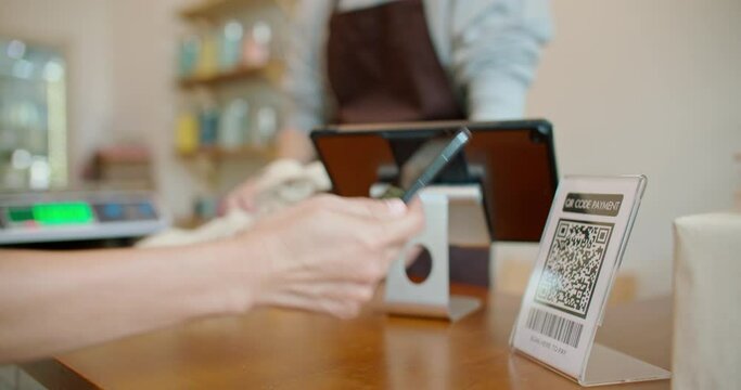 Customer using smartphone scanning shop QR code for contactless paying at zero waste plastic free grocery store. Cashless payment lifestyle. Small business go green startup for reduce climate change.

