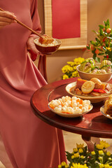 A model holding chopsticks and a bowl of rice with pork belly on top. Front view
