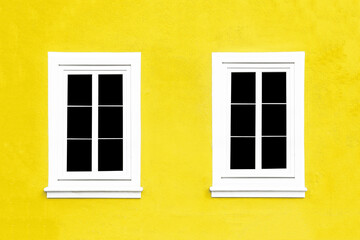PVC Windows. Architecture background. Vibrant color yello wall facade. Small town house exterior. Street of European city building. Two window frames isolated on empty wall. Simple windows in a row.