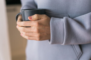Close-up man with cup of coffee. Guy drinks coffee sitting near window