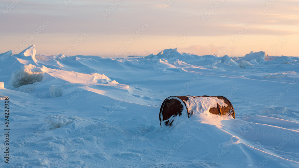 Wall mural a rusty barrel on the shores of a frozen sea in the arctic. problems of ecology and environmental po