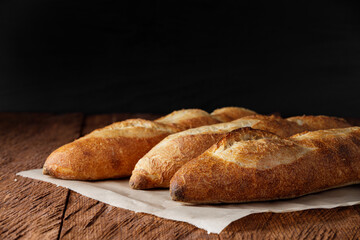 Three artisan baguettes on a stone table and a dark background close-up