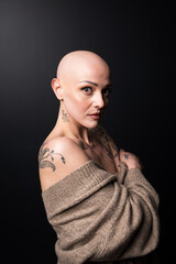 beautiful girl with alopecia and tattoo on dark background