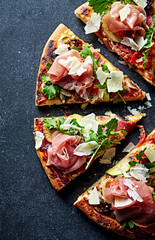 Pizza topped with serrano ham, arugula and grana padano cheese. Top view.  - 574229966