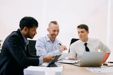 Office colleagues have a casual discussion. During a meeting in conference room, a group of business teem sit in the conference room new startup project..