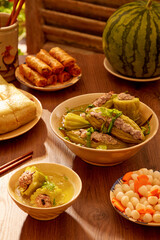 A bowl of pork stuffed bitter melon soup, a dish of pickled small leeks watermelon and watermelon. Tet holiday concept
