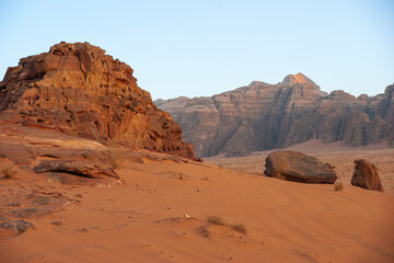 Bizarre shapes of rocks in deserted desert. Jordan. Desert of Wadi Rum. Landscape is similar to Martian landscapes. Sand is of beautiful pink color in rays of setting sun. Nature concept for design
