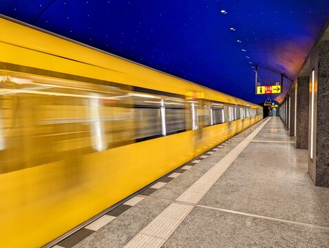 Berlin, November 7, 2021: 'Museumsinsel' (Museum Island) underground station in Berlin Mitte. A subway arrives with motion blur. The ceiling of the station is modeled on a starry sky with LEDs.