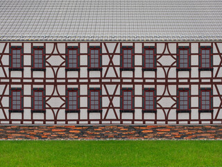 Historische Hausfassade mit Rasenfläche und Bruchsteinmauer