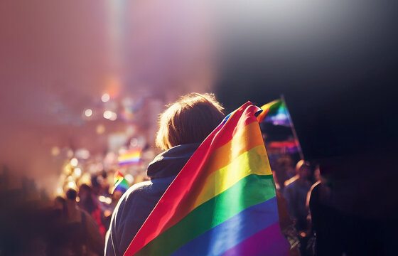 LGBT flag holding with group of people in the background