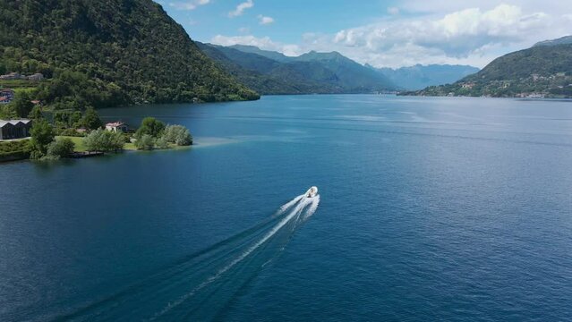 Aerial shot of a boat sailing on the lake of pella, in piedmont, Italy. Picturesque landscape