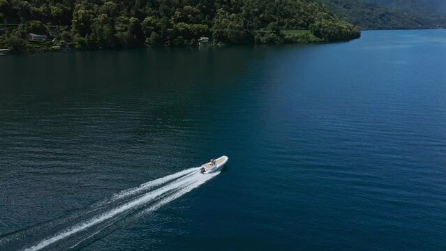 Boat sailing on the lake of Pella, in Piedmont, Italy. Picturesque landscape. Aerial shot. 