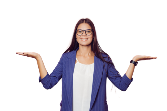 Young brunette in glasses dressed in a dark blue jacket and white blouse, with happy surprise spreads her hands, smiling wide, over transparent background. Shopping and lifestyle concept.