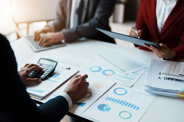 Team business adviser meeting to analyze and discuss the situation on the financial report n the meeting room with using calculator, documents, computer laptop in work.