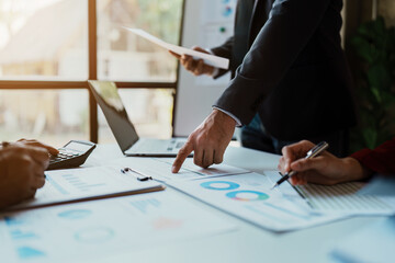 Team business adviser meeting to analyze and discuss the situation on the financial report n the meeting room with using calculator, documents, computer laptop in work.