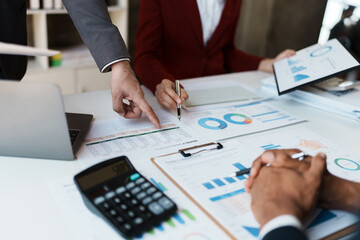 Team business adviser meeting to analyze and discuss the situation on the financial report n the meeting room with using calculator, documents, computer laptop in work.