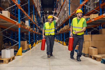 Two warehousemen are rushing to put out the fire in facility.