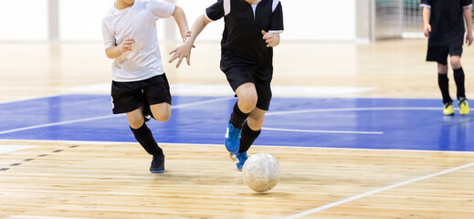 School boys on indoor football tournament game. Football futsal players, ball, futsal floor. Indoor...