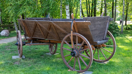 alter Pritschenwagen aus Holz auf einer grünen Wiese abgestellt