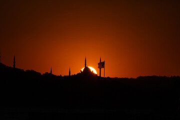 Fatih Mosque and Flag with sun at sunset. Silhoeutte of Istanbul