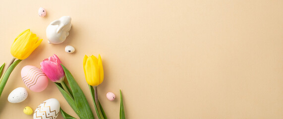 Easter concept. Top view photo of colorful easter eggs ceramic bunny and tulips on isolated pastel beige background with copyspace