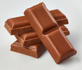 Vollmilchschokoladenriegel gestapelt auf weiss als Freisteller